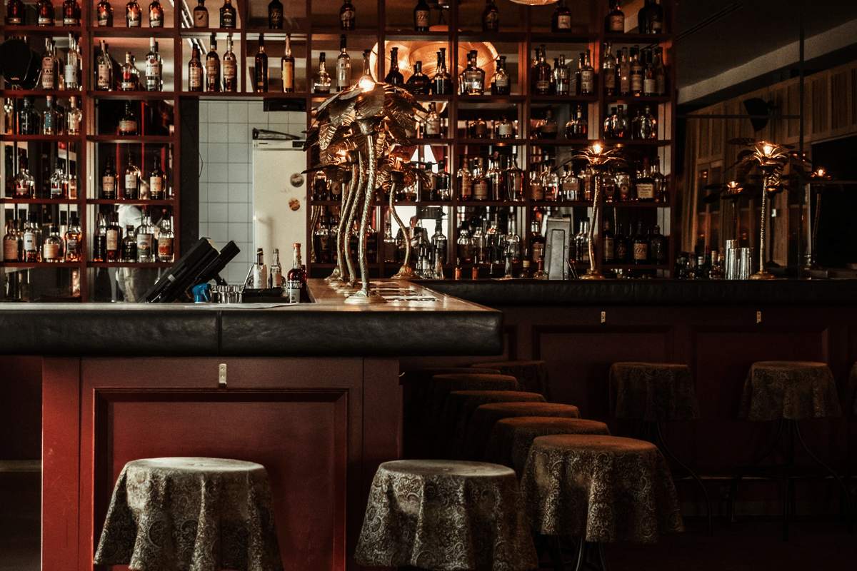 The Ember Bar: twelve stools at the counter, bottles on the back bar.